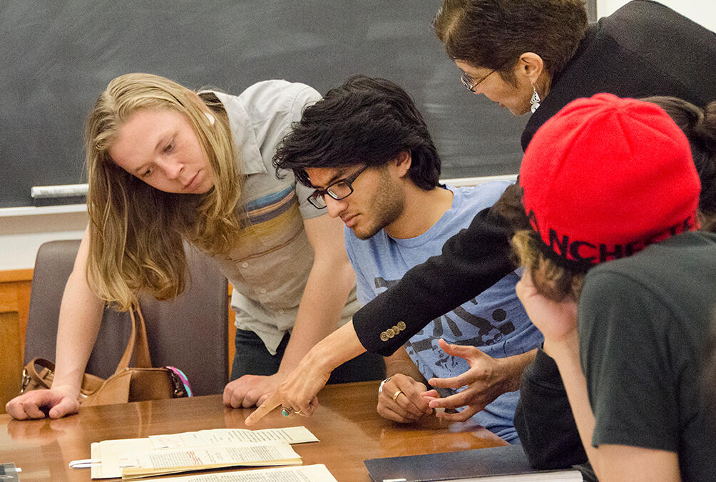 students around a table looking at documents